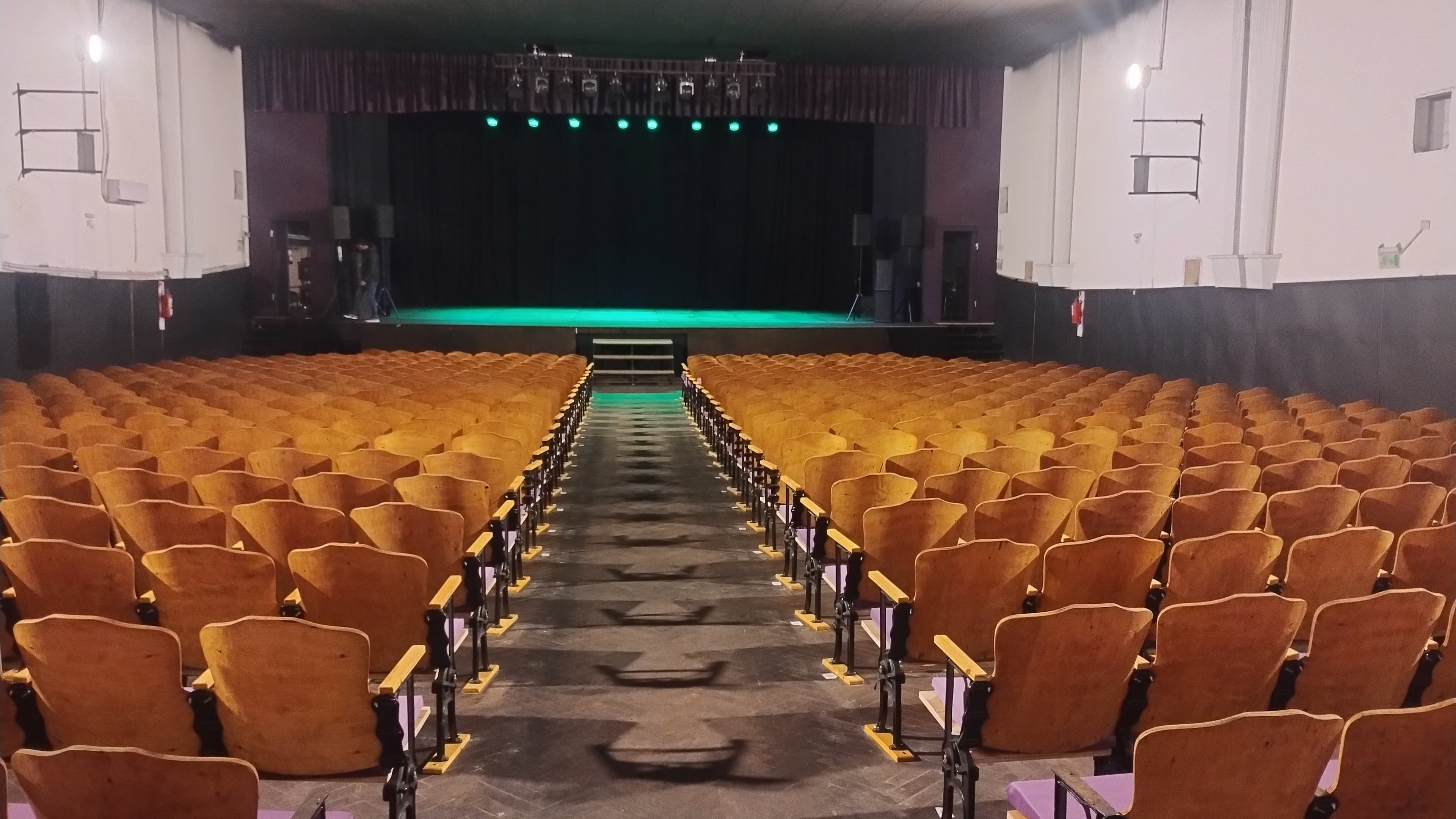 Sala del Teatro ADN vista desde el fondo, con el escenario iluminado